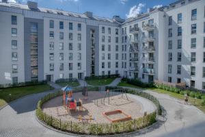 un parque infantil frente a un gran edificio en B12 Apartments by Marina Gdańsk - Old Town, en Gdansk