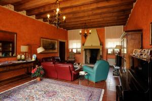 sala de estar con muebles de cuero y chimenea en Corte Beatrice, en Novaglie