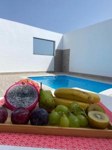 uma bandeja de frutas numa mesa ao lado de uma piscina em Villas Thiago em Tinajo