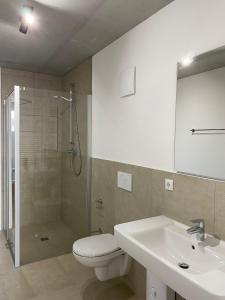 een badkamer met een douche, een toilet en een wastafel bij City Apartments Kaiserslautern in Kaiserslautern