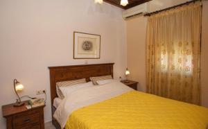 a bedroom with a large bed with a yellow blanket at Argyro House I in Rethymno Town