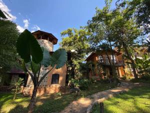 una casa con una palmera delante de ella en Little Eden Guesthouse, en Pang Mapha