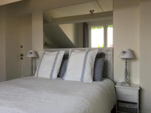 ミラノにあるアパートメント ピエド ア テレ ウィズ テラッツァ イン ミラン シティ センターのベッドルーム1室(白いシーツと枕のベッド1台付)