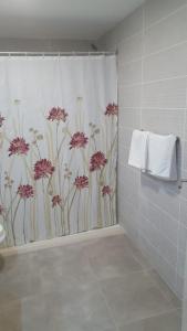 a bathroom with a shower curtain with pink flowers at Apartamentos Florida Gran Canaria Adults Only in Puerto Rico de Gran Canaria