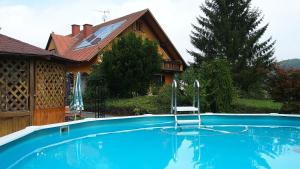 a swimming pool in front of a house at Gästehaus Ulbl in Kitzeck im Sausal