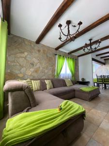 uma sala de estar com um sofá e cortinas verdes em Villas Thiago em Tinajo