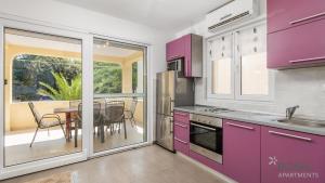 a kitchen with purple cabinets and a table at Rona apartments Goran in Šimuni