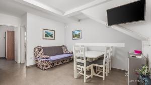 a living room with a table and a chair and a tv at Rona apartments Goran in Šimuni