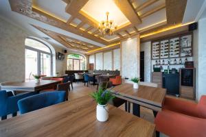 a restaurant with tables and chairs and a bar at Garni Hotel Royal Crown in Subotica