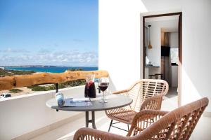 een tafel en stoelen op een balkon met uitzicht op de oceaan bij Gaviota - Emar Hotels Adults Only in Es Calo