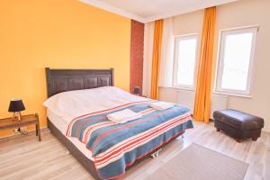 a bedroom with a large bed and two windows at My Home Cappadocia Stone House in Goreme