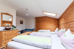 two beds in a room with wooden walls at Hafnerhof in Einöden