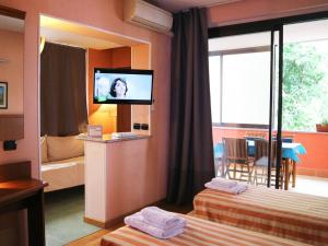ボルゴマネーロにあるHotel Rinaldo Apartmentのベッド2台、薄型テレビが備わるホテルルームです。