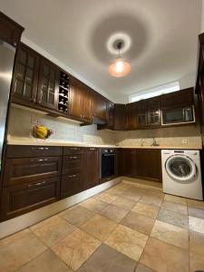 uma cozinha com armários de madeira e uma máquina de lavar roupa em Villas Thiago em Tinajo