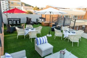 a patio with tables and chairs on a roof at LOCH LOGAN HOTEL in Bloemfontein