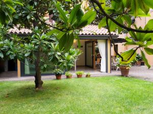 une maison avec un arbre en face d'une cour dans l'établissement La Magnolia B&B, à Bologne