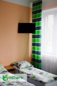 a bedroom with a bed and a green and white curtain at Hostel Noclegi Chorzow in Chorzów