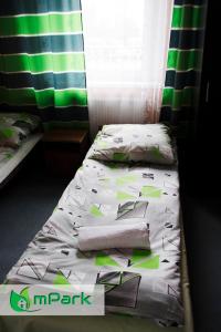 a bedroom with two beds with green and white sheets at Hostel Noclegi Chorzow in Chorzów