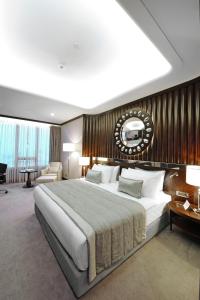 a bedroom with a large bed with a wooden wall at Crowne Plaza Bursa Convention Center & Thermal Spa, an IHG Hotel in Bursa