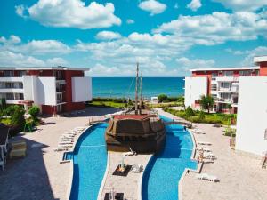 una piscina en un complejo con un barco en Privillege Fort Noks Beach Apartments, en Elenite