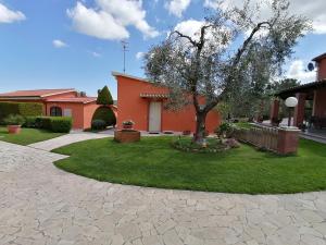 una casa con un árbol en el patio en Agriturismo Galeazzi, en Marsiliana