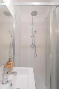 een witte badkamer met een douche en een wastafel bij Vence...sur les pas de Matisse in Vence