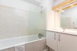 une salle de bain avec une baignoire, un lavabo et une douche dans l'établissement Résidence Odalys Les Sybelles, à Saint-Sorlin-dʼArves 30 autres photos