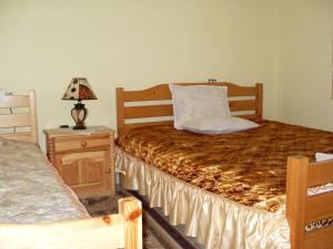 a bedroom with two beds and a table with a lamp at Guest House Rimski Most in Melnik