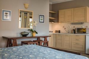 a kitchen with a white bedspread and white cabinets at Balhambra Suites - Adults Only in Fiskardo
