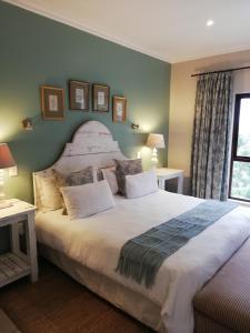 a bedroom with a large bed and a window at Mahogany Villa Guesthouse - SOLAR in Ballito