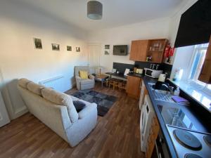 a kitchen and living room with a couch and a table at Stylish 2nd Floor Georgian Period Flat in Dumfries +13 photos