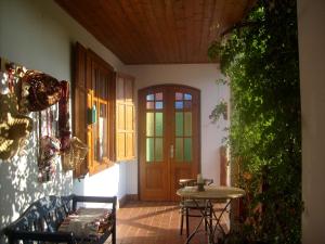 a room with a door and a table and a bench at Nora Porta in Palkonya