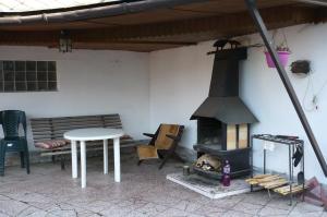 eine Terrasse mit einem Herd, einem Tisch, einem Tisch und einer Bank in der Unterkunft Ubytování LENKA in Bělá pod Pradědem