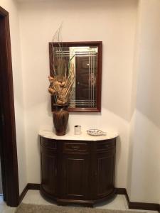 La salle de bains est pourvue d'un miroir et d'un vase sur un comptoir. dans l'établissement Apartamento F.A, à Pedrógão