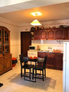 Il comprend une cuisine équipée d'une table, de chaises et d'une cuisinière. dans l'établissement Apartamento F.A, à Pedrógão