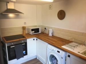 a kitchen with a washing machine and a microwave at Yairbrig Holiday in Galashiels