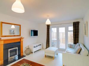 a living room with a couch and a fireplace at Swallows Sea Cottage in Camber