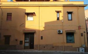 un edificio giallo con una porta sul lato di Casa Vacanza Trappeto Palermo a Trappeto