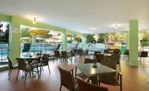 a restaurant with tables and chairs and a patio at Hotel Abacus in Cesenatico