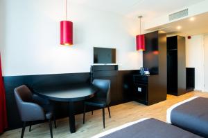 a hotel room with a couch and a television at Bastion Hotel Tilburg in Tilburg