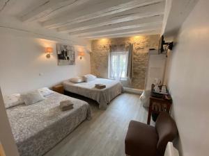 a room with two beds and a chair in it at La Ferme de Labbeville in Labbeville
