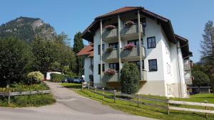 a white building with flower boxes on the balconies at Ferienwohnung Allgäublick Regina in Bad Hindelang