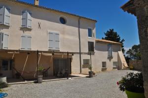 un gran edificio blanco con ventanas y un patio en Le gîte du Jas Vieux, en Montfort