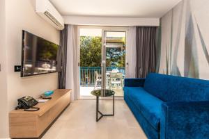 a living room with a blue couch and a table at Arena Verudela Beach in Pula