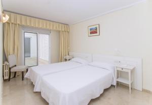 A bed or beds in a room at Seafront Ap Acuario