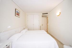 A bed or beds in a room at Seafront Ap Acuario