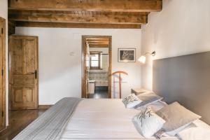 1 dormitorio con 1 cama con sábanas y almohadas blancas en Casa Salient by Totiaran, en Escuñau