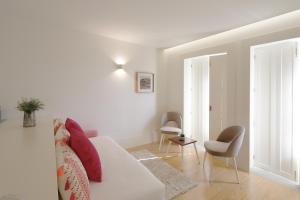 uma sala de estar branca com um sofá branco e cadeiras em HM - Historical Studio Taipas 3E no Porto