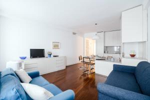 a living room with a blue couch and a kitchen at Downtown Como-Porta Torre Flat in Como