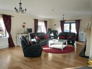 a living room with two couches and a table at Cnocan Na Cuaig Carraroe by Trident Holiday Homes in Carraroe